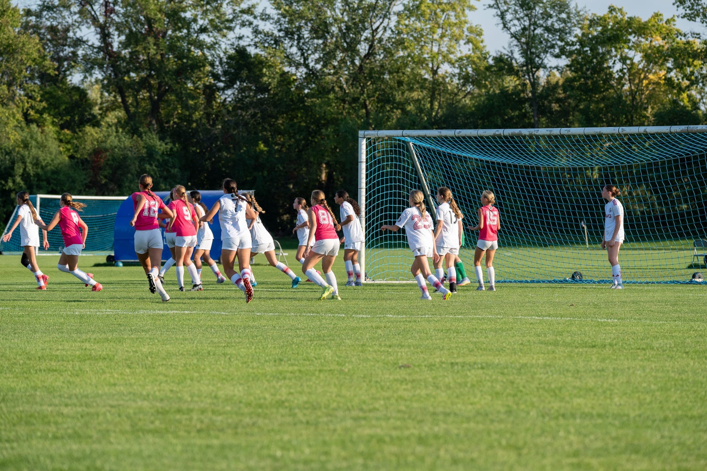 Soccer players driving toward goal in Chicagoland match coverage